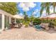 Backyard brick patio with multiple seating areas, umbrellas, grill area, and lush landscaping at 904 Clubhouse Blvd, New Smyrna Beach, FL 32168