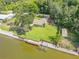 Aerial view of home with waterfront, dock, well-maintained yard, and large trees at 154 Godfrey Rd, Edgewater, FL 32141
