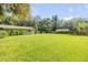 Expansive, green backyard with lush grass, mature trees, and a storage shed at 154 Godfrey Rd, Edgewater, FL 32141