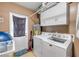 Functional laundry room with modern washer and dryer, ample storage cabinets, and convenient access to outside at 154 Godfrey Rd, Edgewater, FL 32141