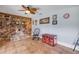 Bright living room with a stone fireplace, tile flooring, and a decorative ceiling fan at 154 Godfrey Rd, Edgewater, FL 32141