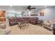 Spacious living room with tile flooring, a large brown sectional, and an open layout, perfect for entertaining guests at 154 Godfrey Rd, Edgewater, FL 32141