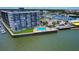 Expansive aerial view of harborside apartment building with swimming pool and boats docked nearby at 101 N Riverside Dr # 1090, New Smyrna Beach, FL 32168