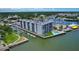 Aerial view of waterfront condo boasting lush landscaping, boat docks, and a pool, ideal for leisure at 101 N Riverside Dr # 1090, New Smyrna Beach, FL 32168