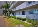 Condominium exterior featuring lush greenery, including palm trees and manicured bushes, creating a tropical oasis at 101 N Riverside Dr # 1090, New Smyrna Beach, FL 32168
