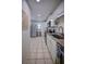 Galley kitchen featuring white cabinets, stainless appliances, granite counters, and tile flooring at 101 N Riverside Dr # 1090, New Smyrna Beach, FL 32168