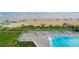 This aerial photo captures a swimming pool with lounge chairs and overlooks the beach and ocean at 1051 Ocean Shore Blvd # 502, Ormond Beach, FL 32176