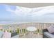 Comfortable seating and a small table are on an outdoor balcony with amazing views of the beach and ocean at 1051 Ocean Shore Blvd # 502, Ormond Beach, FL 32176