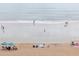Scenic beach view featuring calm waves, sandy shores, and people relaxing under umbrellas at 1051 Ocean Shore Blvd # 502, Ormond Beach, FL 32176