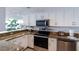 Updated kitchen featuring granite countertops, stainless steel appliances, and white cabinetry at 1051 Ocean Shore Blvd # 502, Ormond Beach, FL 32176