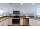 Well-lit kitchen featuring white cabinets, granite counters, and stainless steel appliances at 1051 Ocean Shore Blvd # 502, Ormond Beach, FL 32176