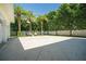 Large concrete backyard featuring palm trees and comfortable swinging chairs at 1212 S Riverside Dr, New Smyrna Beach, FL 32168