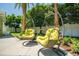 Backyard featuring mature palm trees and comfortable hanging chairs at 1212 S Riverside Dr, New Smyrna Beach, FL 32168