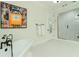 Bright bathroom with freestanding tub, walk-in glass shower, and artistic wall decor at 1212 S Riverside Dr, New Smyrna Beach, FL 32168