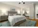 Bedroom with a ceiling fan, mirrored closet doors, and hardwood floors with area rug at 1212 S Riverside Dr, New Smyrna Beach, FL 32168