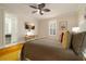 Comfortable bedroom with a desk, ceiling fan, TV, window, and connecting bathroom at 1212 S Riverside Dr, New Smyrna Beach, FL 32168