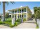 Stately two-story yellow home with white columns, balconies, dark shutters, iron gate and manicured lawn at 1212 S Riverside Dr, New Smyrna Beach, FL 32168