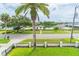 Exterior view of the property, featuring a palm tree, lush landscaping and waterfront views at 1212 S Riverside Dr, New Smyrna Beach, FL 32168