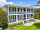 Stunning yellow two-story home with a double-decker porch and beautiful landscaping at 1212 S Riverside Dr, New Smyrna Beach, FL 32168