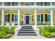 Charming porch with comfortable seating, black shutters, and lush landscaping at 1212 S Riverside Dr, New Smyrna Beach, FL 32168