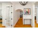 Bright hallway boasts white wainscoting, hardwood floors, and stylish light fixtures at 1212 S Riverside Dr, New Smyrna Beach, FL 32168