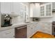 This kitchen features stainless steel appliances, custom white cabinets, countertops, and a large window for natural light at 1212 S Riverside Dr, New Smyrna Beach, FL 32168