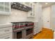 Gourmet kitchen features stainless steel Wolf appliances, custom cabinets, and stone countertops with marble backsplash at 1212 S Riverside Dr, New Smyrna Beach, FL 32168