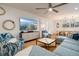 Spacious living room with comfortable seating, a ceiling fan, and a view of the dining area at 1212 S Riverside Dr, New Smyrna Beach, FL 32168
