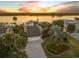 Aerial view of a home with mature landscaping, a long driveway, and an attached garage at 1219 Commodore Dr, New Smyrna Beach, FL 32168