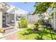 Charming backyard featuring a pergola, lush lawn, mature landscaping, and a decorative bird bath centerpiece at 1219 Commodore Dr, New Smyrna Beach, FL 32168