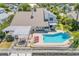 An inviting backyard oasis features a refreshing pool, pergola-covered patio, and scenic waterfront views at 1219 Commodore Dr, New Smyrna Beach, FL 32168