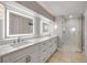 Modern bathroom featuring double vanity with LED lighting, granite countertops, and a glass-enclosed shower at 1219 Commodore Dr, New Smyrna Beach, FL 32168