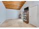 Bedroom featuring wood paneled vaulted ceilings, travertine floors, and natural light at 1219 Commodore Dr, New Smyrna Beach, FL 32168