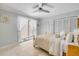 Bedroom featuring travertine floors, a ceiling fan, a sliding glass door to a patio, and shuttered closet doors at 1219 Commodore Dr, New Smyrna Beach, FL 32168