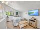 Cozy bedroom featuring a comfortable bed, tv, and a large window with natural light at 1219 Commodore Dr, New Smyrna Beach, FL 32168