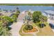 Beautiful waterfront home features lush landscaping, a circular driveway, and an attached two-car garage at 1219 Commodore Dr, New Smyrna Beach, FL 32168