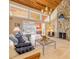 Bright living room featuring a stone fireplace, wood-paneled ceilings, travertine floors, and sliding doors with water views at 1219 Commodore Dr, New Smyrna Beach, FL 32168