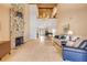Large living room with stone fireplace and tall ceilings overlooking open floor plan and travertine floors at 1219 Commodore Dr, New Smyrna Beach, FL 32168