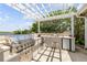 An outdoor kitchen with a built-in grill, sink and mini-refrigerator at 1219 Commodore Dr, New Smyrna Beach, FL 32168