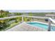 View of pool and river from deck with palm trees and greenery, clear skies on a sunny day at 1219 Commodore Dr, New Smyrna Beach, FL 32168