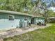 Rear view of property including patio, lush yard, shade trees, and central A/C unit at 1331 Needle Palm Dr, Edgewater, FL 32132