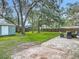 A backyard with a brick patio, grassy area, storage shed, and a hammock hanging between trees at 1331 Needle Palm Dr, Edgewater, FL 32132