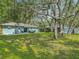 Expansive backyard featuring mature trees, a storage shed, and a well-manicured lawn at 1331 Needle Palm Dr, Edgewater, FL 32132