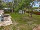 Aerial view of the backyard with a brick patio, shed, hammock, mature trees, and wood fence at 1331 Needle Palm Dr, Edgewater, FL 32132