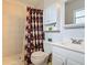 Well-maintained bathroom with a walk-in shower, white cabinets, and neutral tile at 1331 Needle Palm Dr, Edgewater, FL 32132