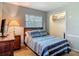Bedroom view with soft lighting, cozy bed, dresser, and window, providing a serene and inviting atmosphere at 1331 Needle Palm Dr, Edgewater, FL 32132