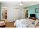 Bright bedroom with white closet doors, a view into an adjacent bathroom, and light-colored wood flooring at 1331 Needle Palm Dr, Edgewater, FL 32132