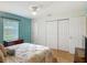 Bright bedroom featuring hardwood floors, a closet, and a cozy bed, offering a comfortable space to unwind at 1331 Needle Palm Dr, Edgewater, FL 32132