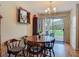 Dining room featuring hardwood floors, sliding glass door to the backyard, and a modern chandelier at 1331 Needle Palm Dr, Edgewater, FL 32132