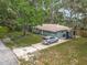 Aerial view of a charming home with a spacious yard, a driveway, and mature trees at 1331 Needle Palm Dr, Edgewater, FL 32132